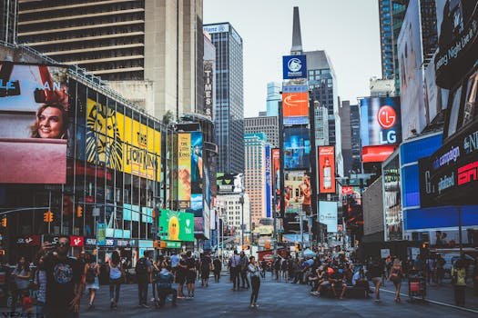 pexels-photo-1486222-1486222-1 Bustling daytime view of Times Square with crowds, skyscrapers, and iconic billboards in New York City.